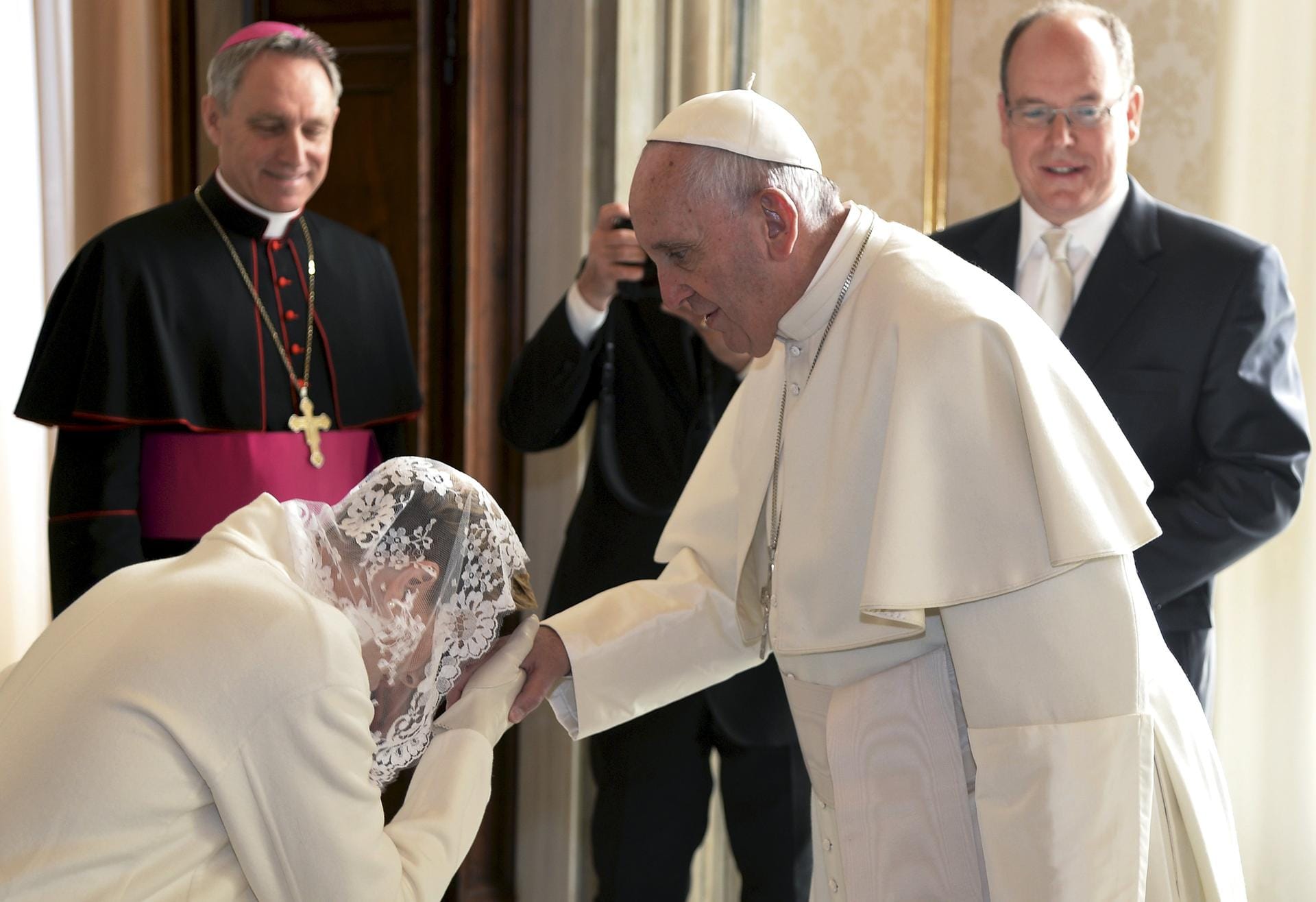 Charlène küsst die Hand des Papstes.
