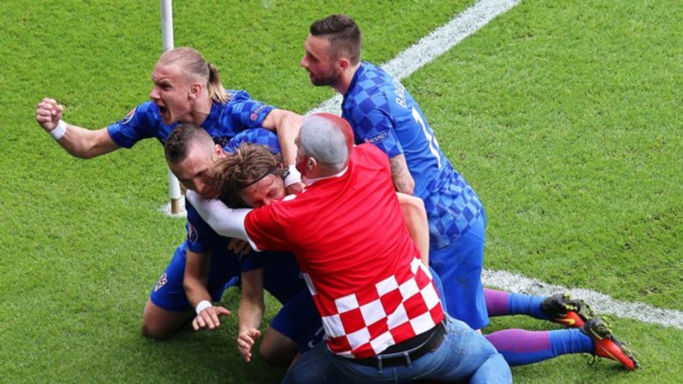 Ein kroatischer Fan überwindet den Sicherheitsbereich und jubelt mit Siegtorschütze Modric.