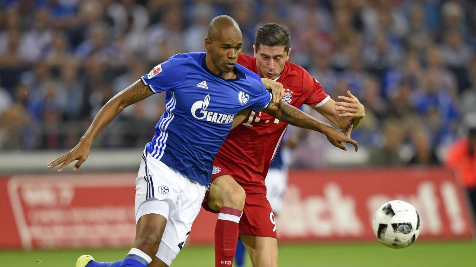 Schalkes Naldo (li.) und Robert Lewandowski vom FC Bayern München jagen dem Ball hinterher. Schalkes Naldo (li.) und Robert Lewandowski vom FC Bayern München jagen dem Ball hinterher.