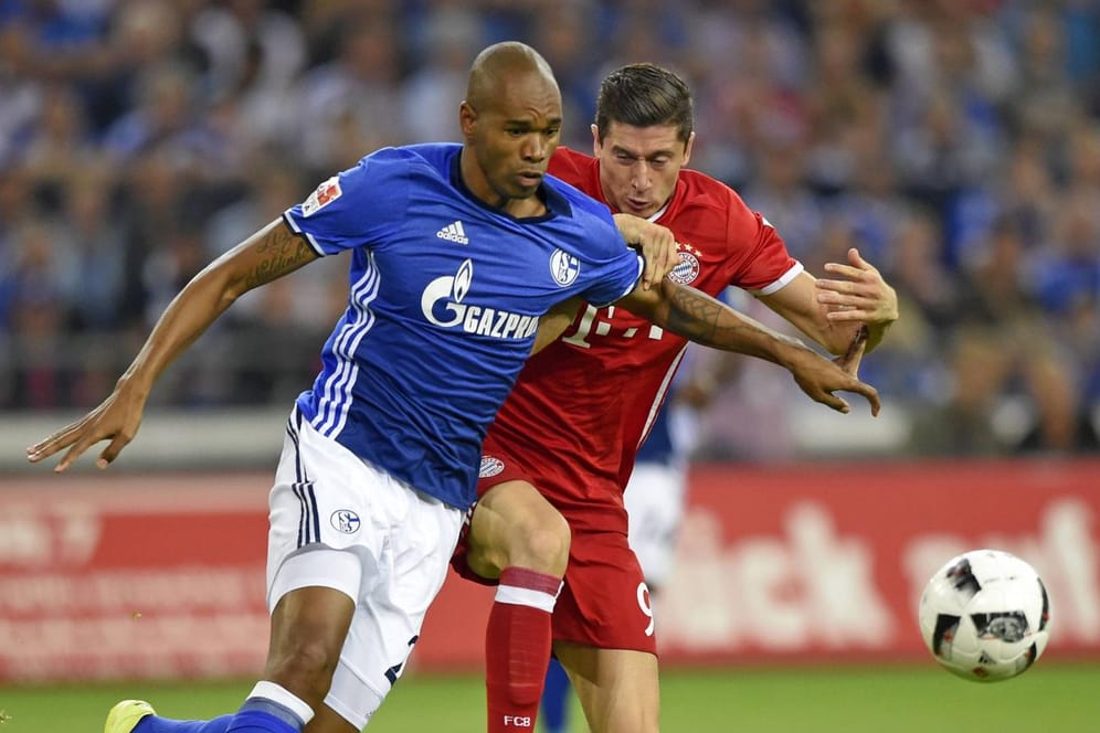 Schalkes Naldo (li.) und Robert Lewandowski vom FC Bayern München jagen dem Ball hinterher.