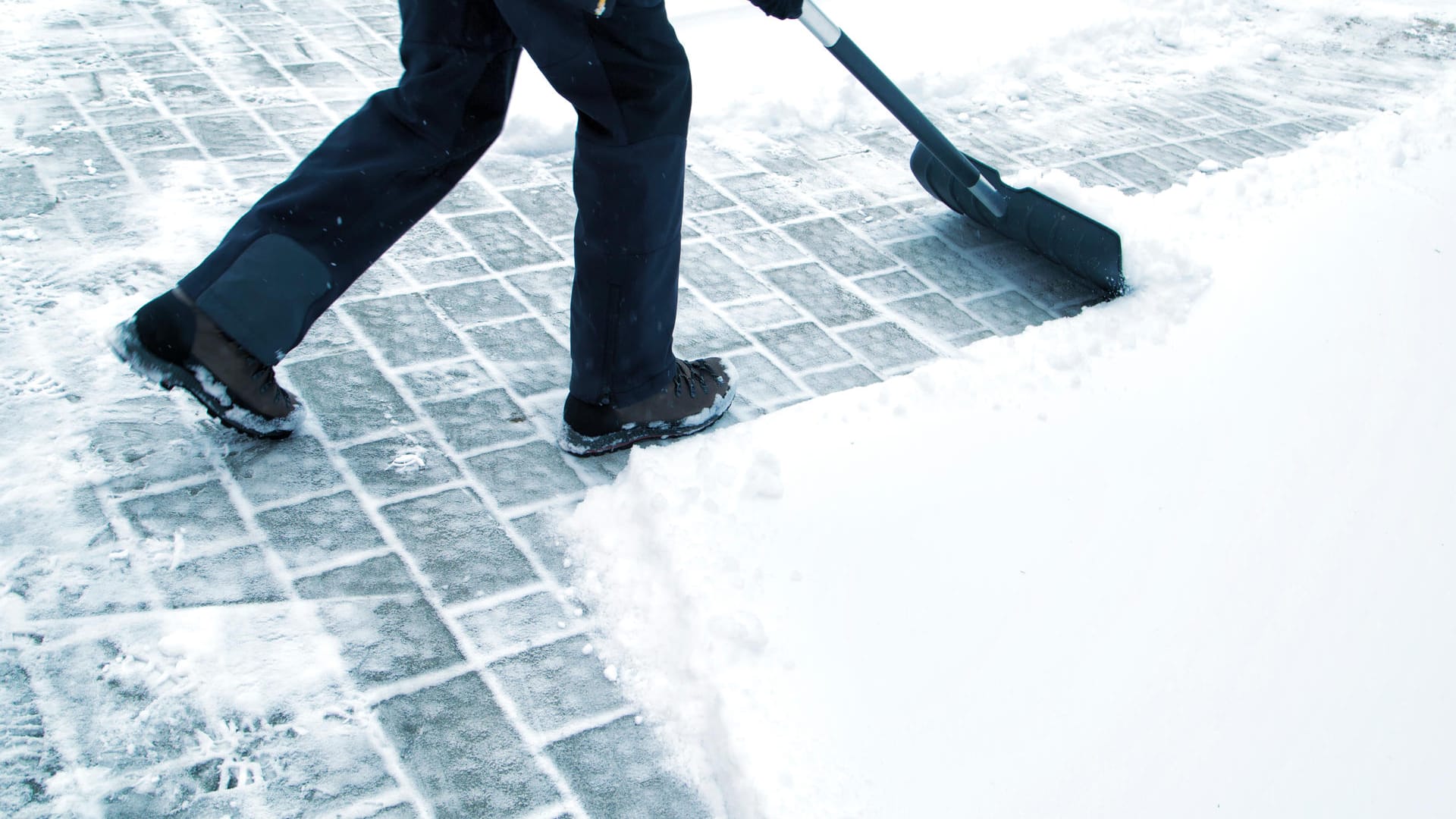 Man with shovel cleaning snow at day light