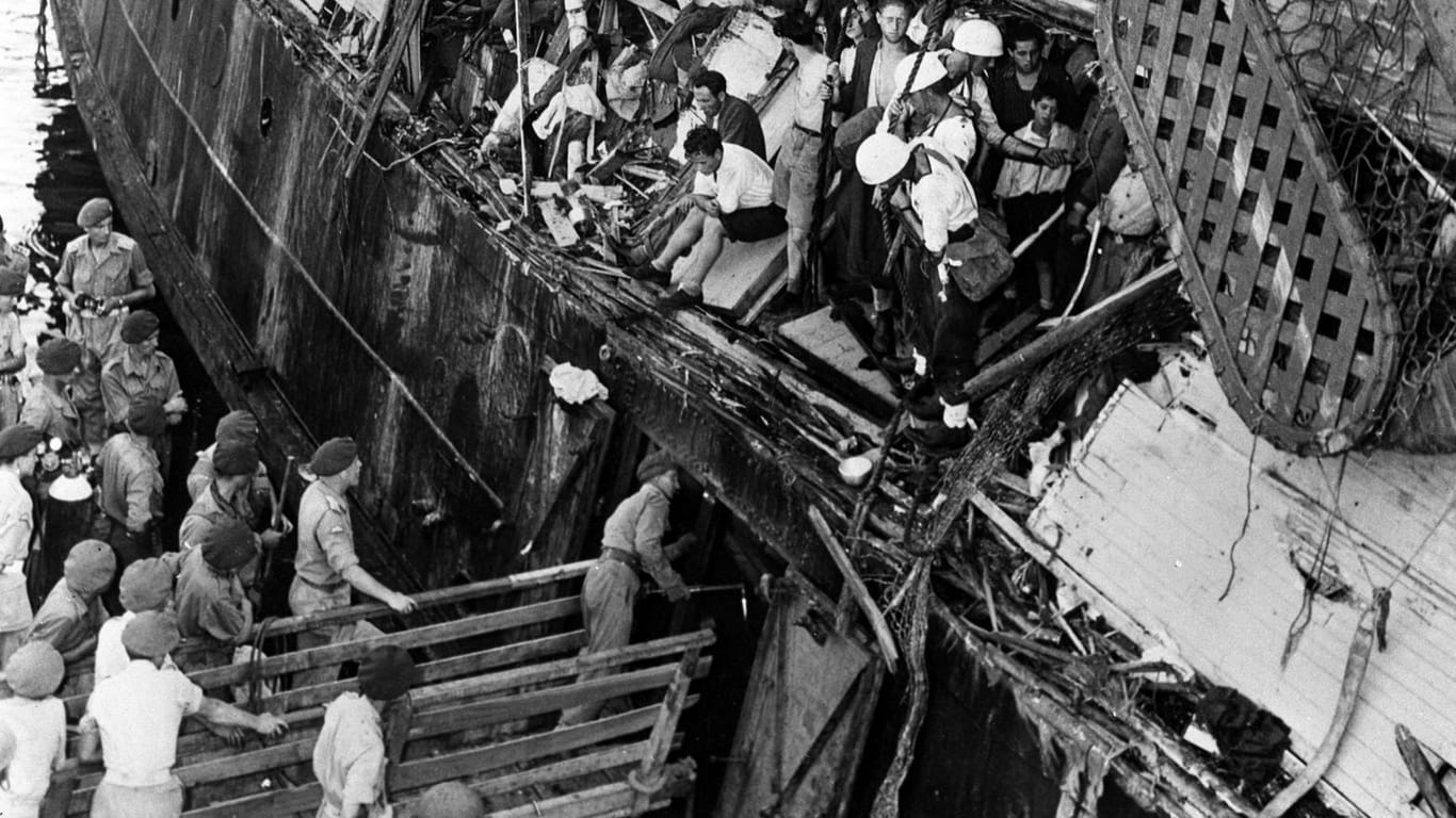 20. Juli 1947: Britische Marinesoldaten bringen die "Exodus" im Hafen von Haifa auf. Im Vordergrund zu sehen: Die Beschädigung durch das Rammmanöver eines Marineschiffs.