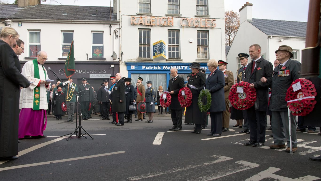 Am Kriegsdenkmal in Enniskillen legen Politiker (darunter Arlene Foster, Vorsitzende der Democratic Unionist Party, schwarzer Hut) am Remembrance Day Kränze nieder.