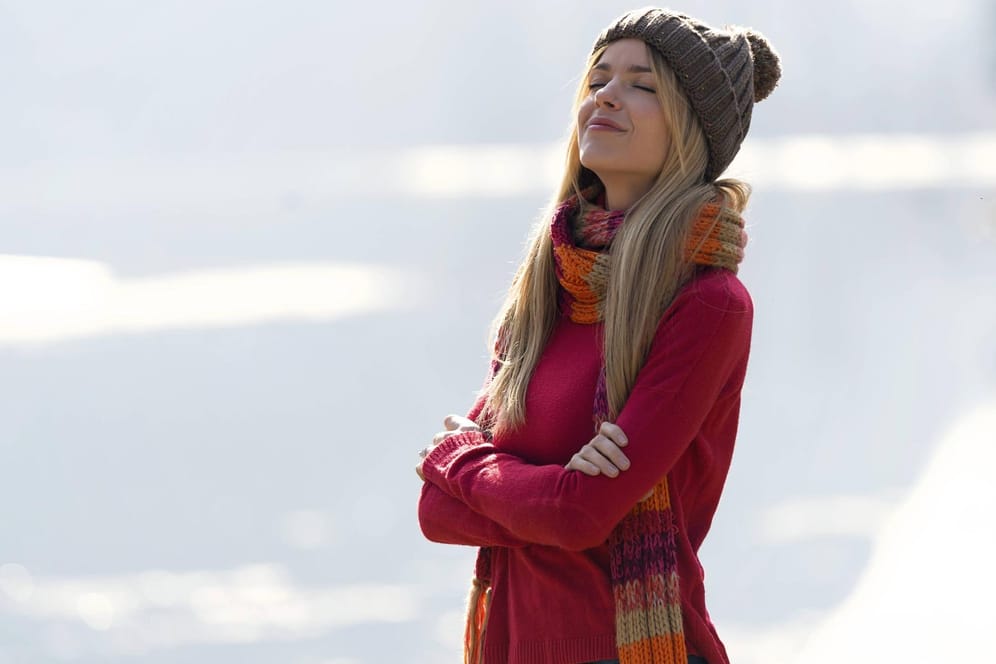Frau in der Natur: Schal und Mütze bieten ausreichend Schutz vor der Kälte und sind ein Muss im Winter.