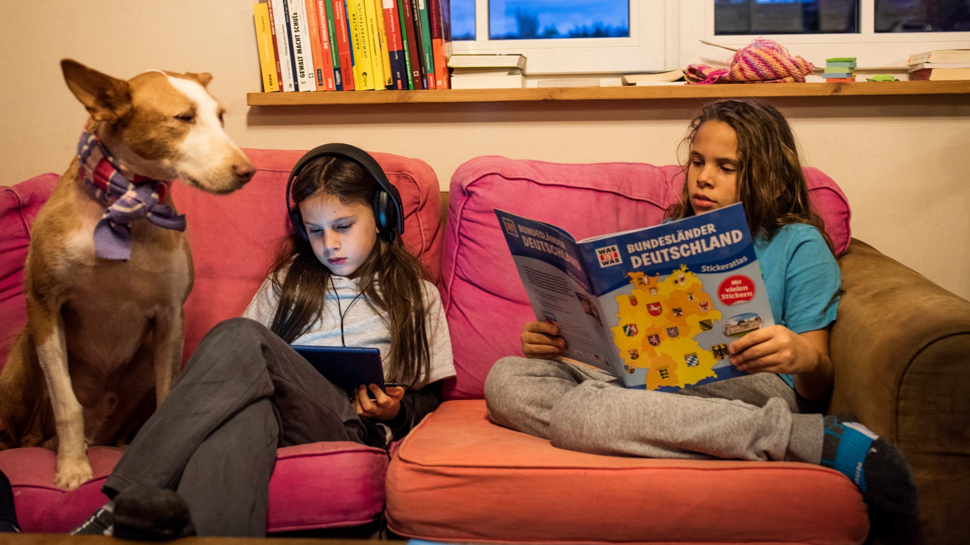 Leif (links) und Finn haben es sich mit Tablet und Buch im Wohnzimmer gemütlich gemacht.