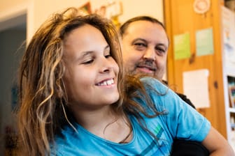 Finn kuschelt mit seinem Vater im Wohnzimmer: "Die Kinder sollen in die Schule gehen, aber nur, wenn es ihnen dort gut geht. Das wäre derzeit nicht der Fall."