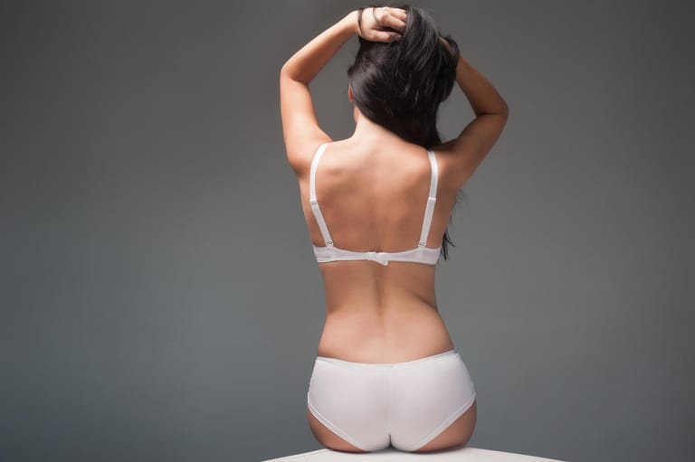 woman's back on grey background in lingerie
