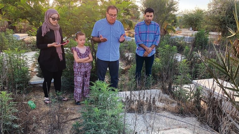 Izzeldin Abuelaish in Gaza am Grab seiner Töchter im Sommer 2021. Neben ihm sein Sohn, seine Tochter und eine Nichte.