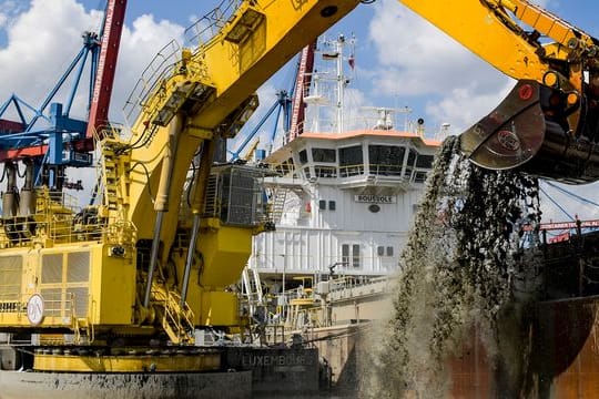 Ein Bagger holt bei Arbeiten zur Elbvertiefung Schlick aus einem Hafenbecken (Archivbild): Der Streit um den Schlick scheint gelöst.