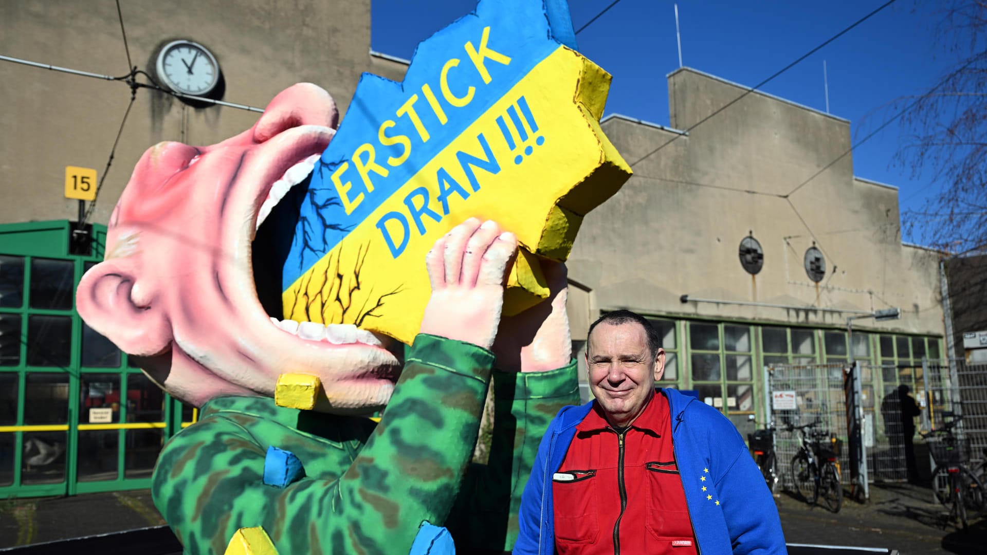 Jacques Tilly steht vor seinem Motivwagen in Düsseldorf.