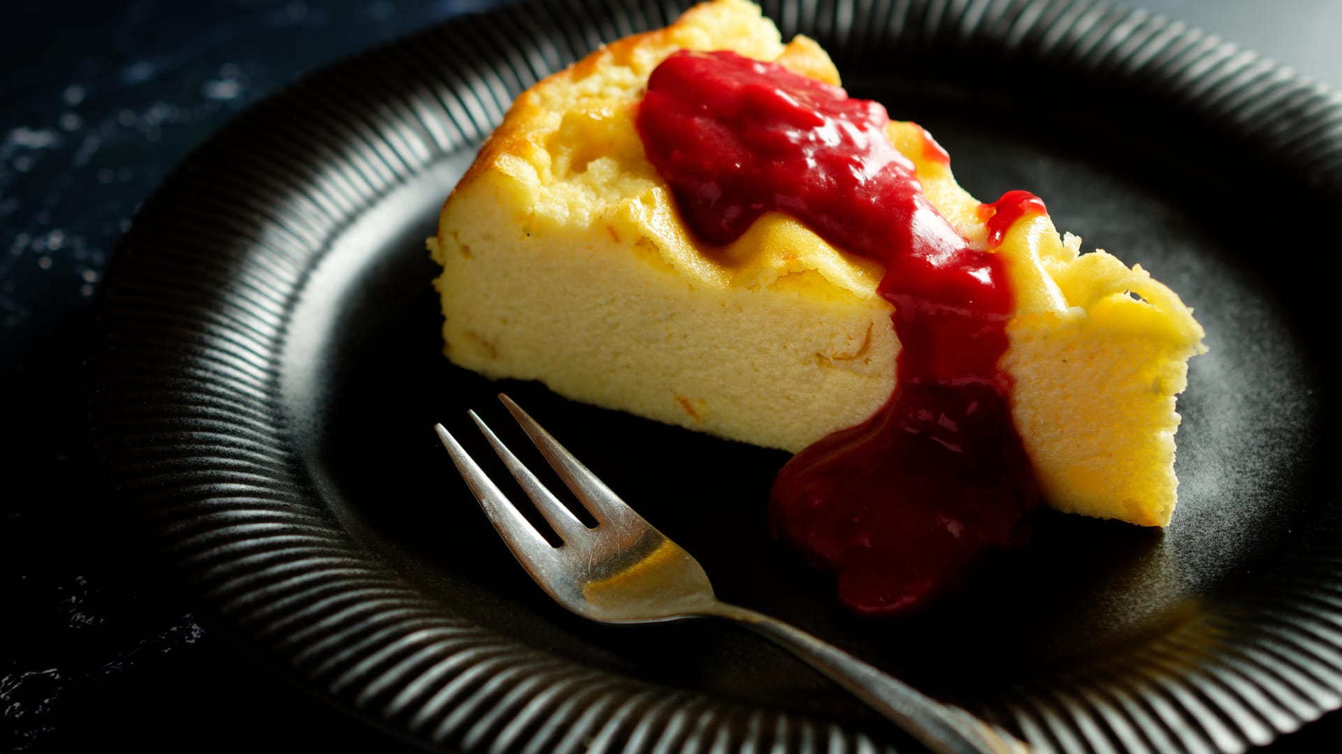 Grieß-Käsekuchen mit Beerensauce: Käsekuchen lässt sich toll mit Toppings wie Beeren-, Schoko- oder Karamellsauce servieren.