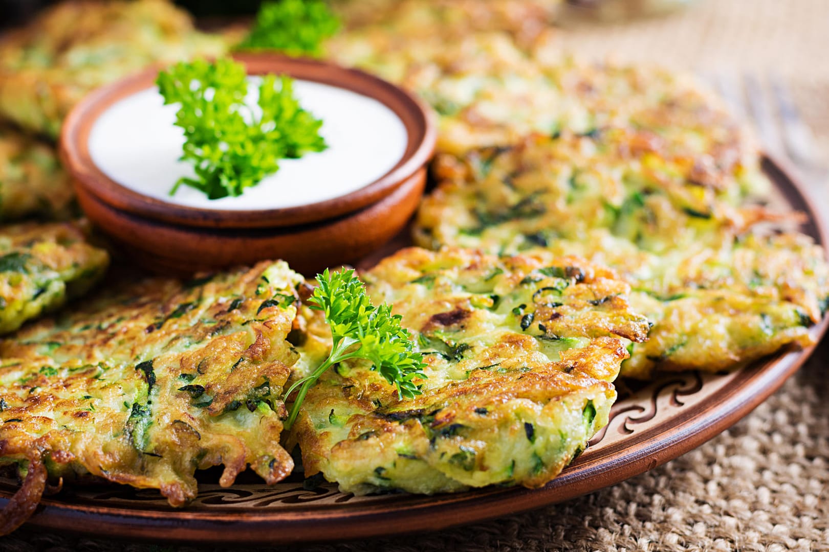 Zucchinifladen mit Joghurt-Dip: Serviert mit leckeren Dips sind Gemüsepuffer ein leckeres Fingerfood.