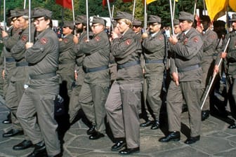 Betriebshauptgruppe Kampfgruppe marschiert mit DDR-Fahnen anlässlich eines Festakts.