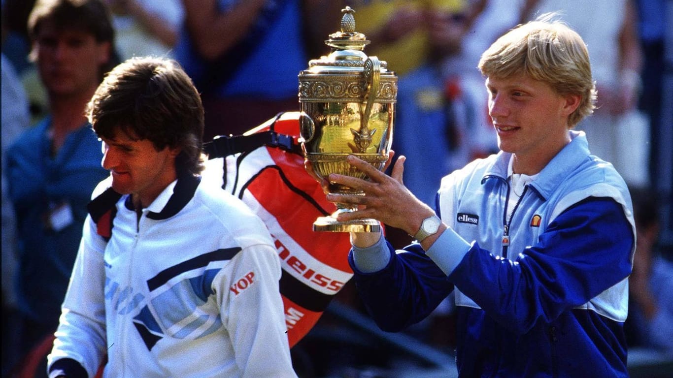 7. Juli 1985: An diesem Tag wurde Boris Becker zum zweiten Mal geboren, wie er selbst gerne sagt. Der damals 17-Jährige mit der Siegertrophäe von Wimbledon. Links der geschlagene Endspielgegner Kevin Curren.