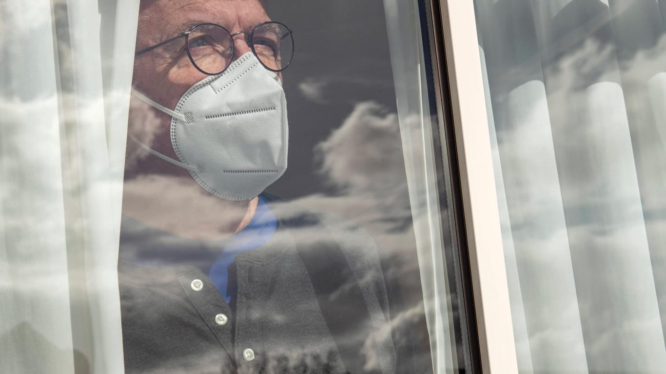 Ein Corona-Patient steht am Fenster (Symbolbild): Langsam sinkt die Inzidenz wieder