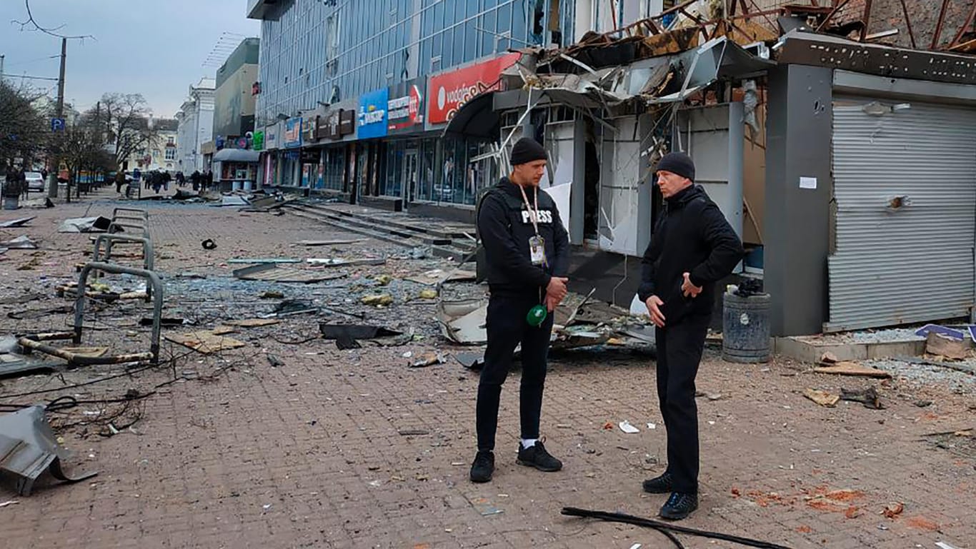 Vadyslav Atroshenko (r), Bürgermeister von Tschernihiw, spricht mit einem Journalisten in der Nähe des Einkaufszentrums, das durch nächtlichen Beschuss beschädigt wurde.