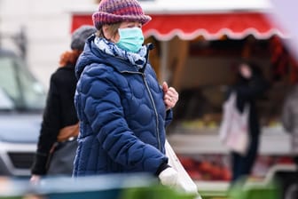 Eine Frau in Leipzig trägt Maske (Archivbild): Ab Sonntag ist dies beim Einkaufen auch in Innenräumen nicht mehr vorgeschrieben.