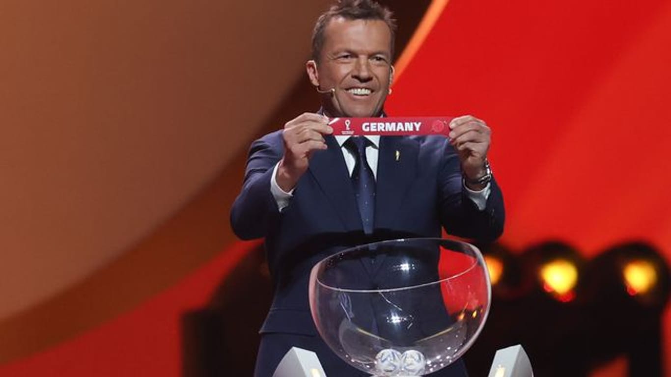 Lothar Matthäus lächelt das er Los von Deutschland in Händen hält.