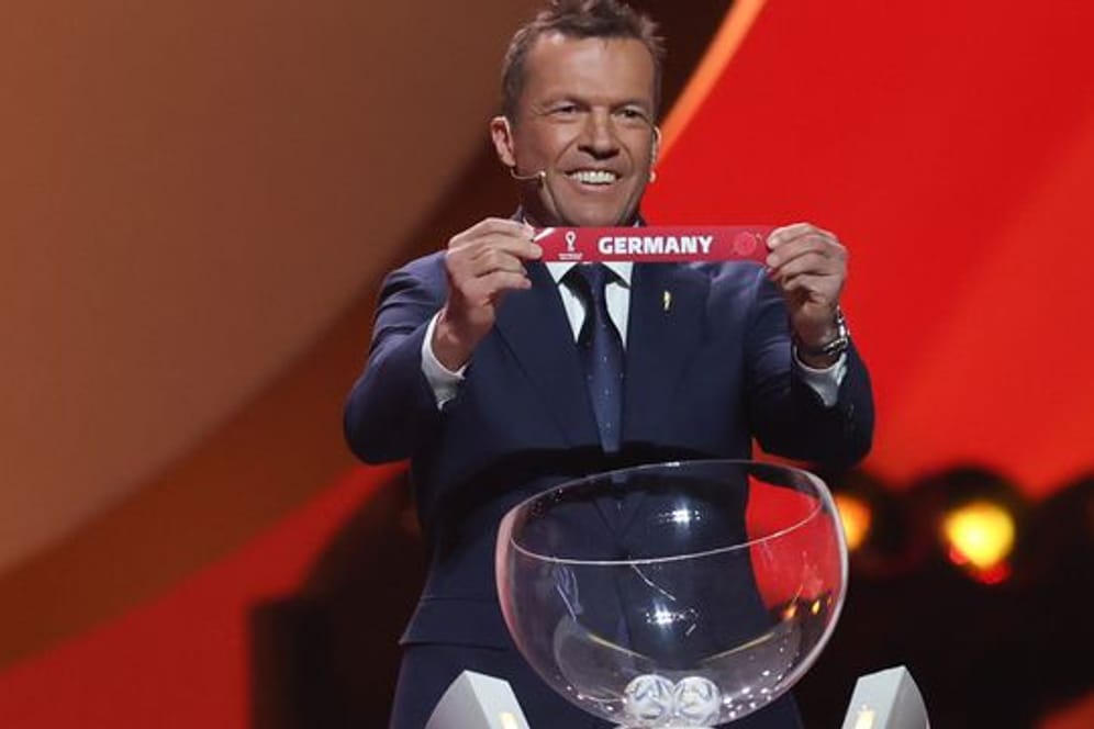 Lothar Matthäus lächelt das er Los von Deutschland in Händen hält.