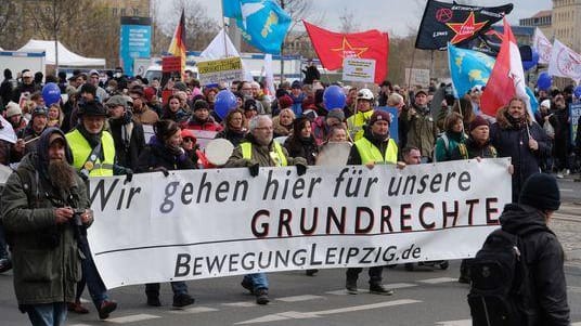 Teilnehmende einer Demonstration von Gegnern der Coronamaßnahmen tragen ein Transparent mit der Aufschrift "Wir gehen hier für unsere Grundrechte".