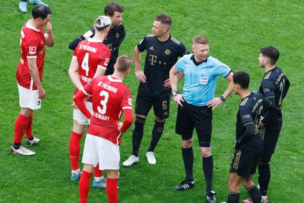Nach dem Wechselfehler der Bayern unterbrach Schiedsrichter Christian Dingert (3.