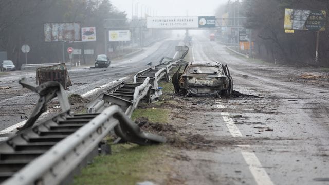 Ein zerstörtes Auto auf einer Landstraße in Butscha.