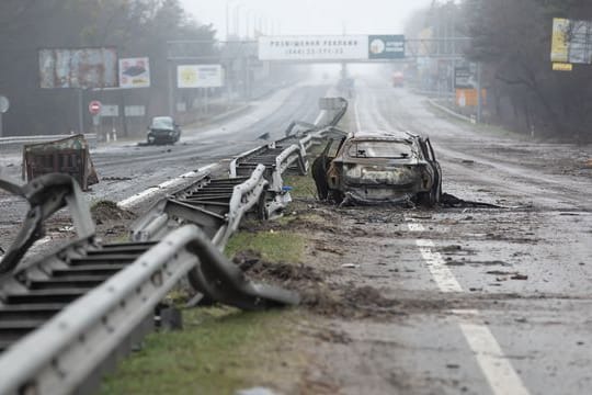 Ein zerstörtes Auto auf einer Landstraße in Butscha.