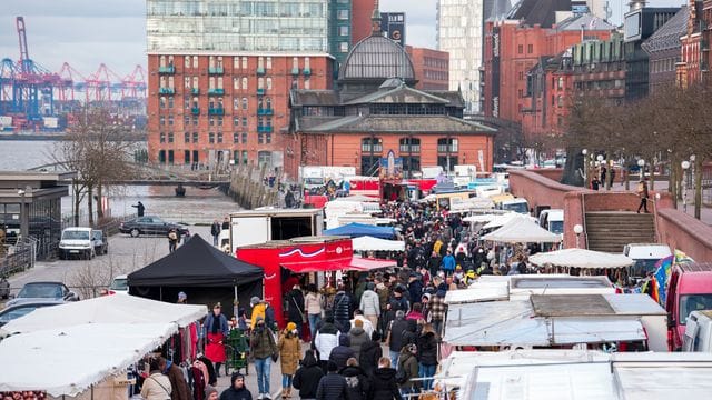 Besucher gehen am Morgen über den Hamburger Fischmarkt an der Elbe. Besucher gehen am Morgen über den Hamburger Fischmarkt an der Elbe.