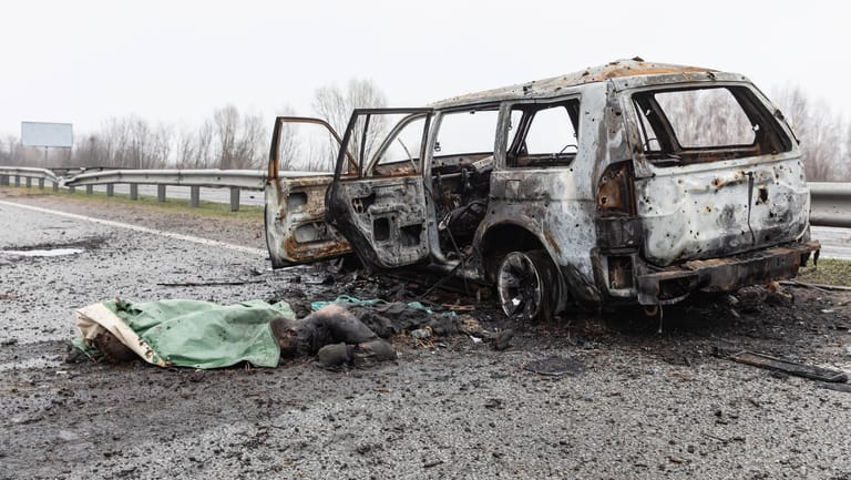 Eine Leiche vor einem verbrannten Auto: Dutzende Zivilisten wurden in Butscha getötet.