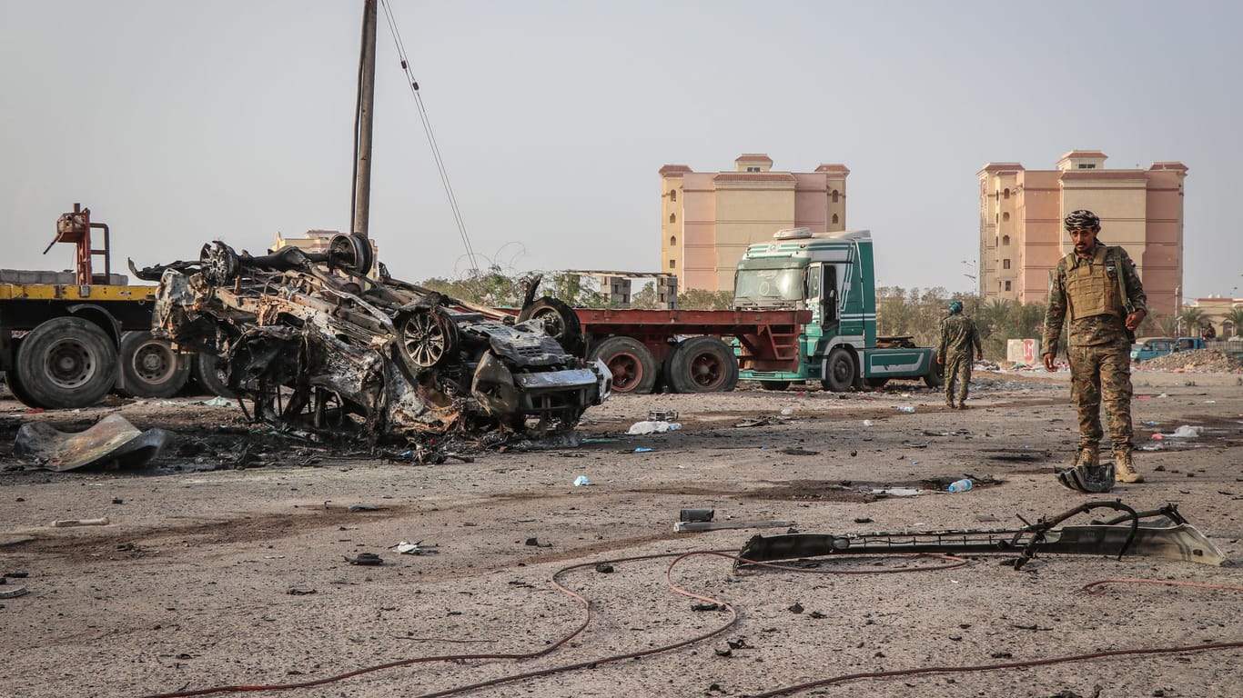 Ein Angehöriger der jemenitischen Sicherheitskräfte inspiziert ein zerstörtes Fahrzeug nach einem Autobombenanschlag: Die Waffenruhe wurde offenbar gebrochen (Archivbild).