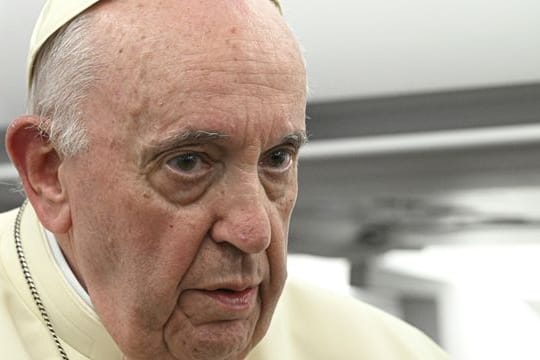 Papst Franziskus hört sich die Fragen der Reporter während einer Pressekonferenz an.