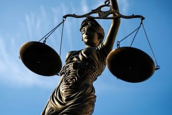 Eine Bronzefigur der Justitia hält eine Waage in der Hand