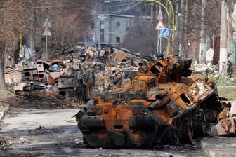 Ukrainische Soldaten untersuchen zerstörte russische Militärfahrzeuge in Butscha.