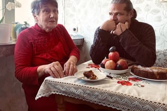Die Holocaust-Überlebende Hanna Stryschkowa und der Fotograf und Filmemacher Luigi Toscano aus Mannheim unterhalten sich an einem Tisch.