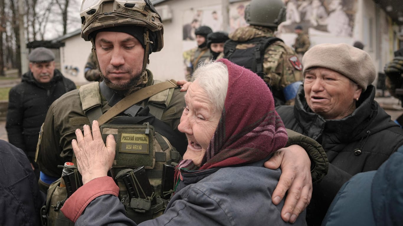 Eine Frau umarmt einen ukrainischen Soldaten, nachdem ein Konvoi von Militär- und Hilfsfahrzeugen in Butscha eingetroffen ist: Die Straßen des Kiewer Vorortes sind übersät mit Leichen.