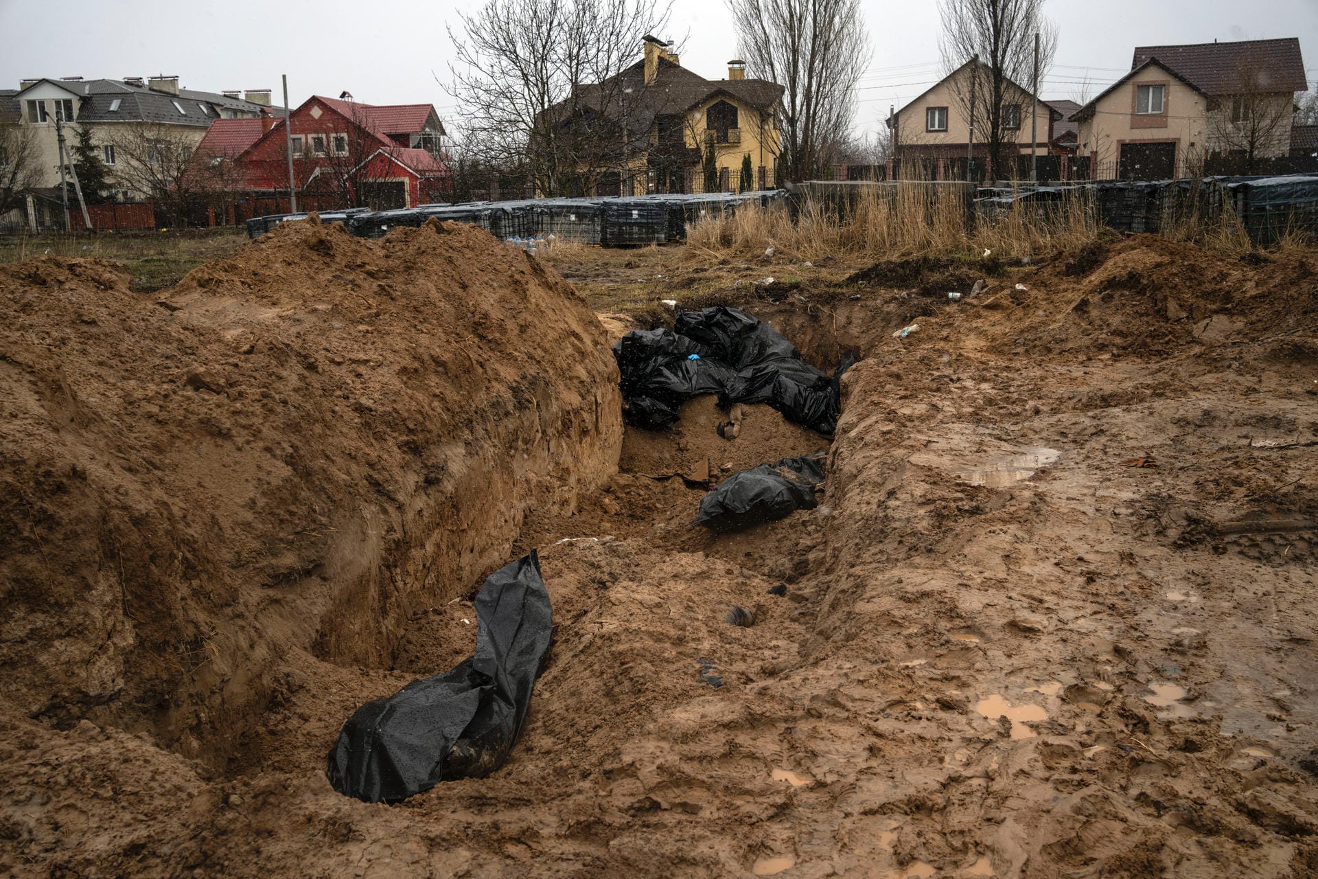 Schwarze Leichensäcke liegen in einem Massengrab. Während der russischen Angriffe konnten viele der getöteten Zivilisten nicht würdig begraben werden.