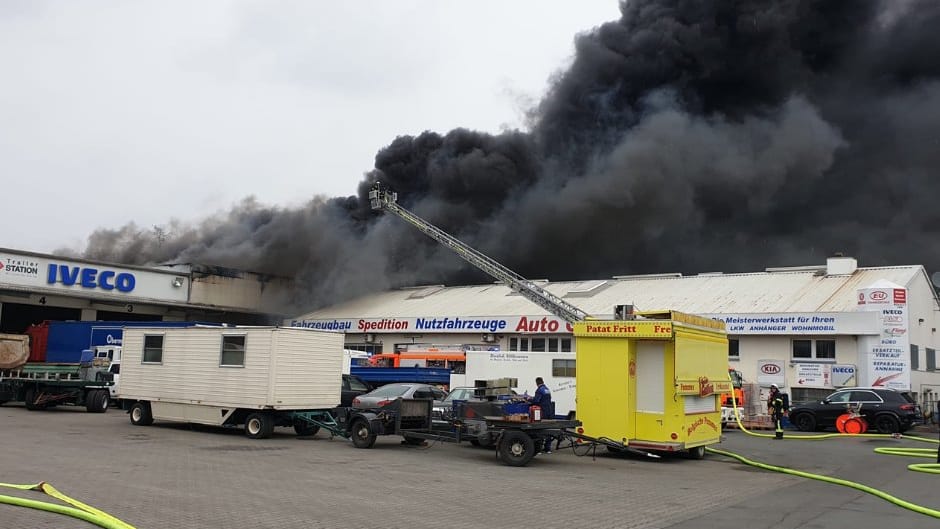 Dichter schwarzer Rauch zieht aus der Lagerhalle: Die Feuerwehr ist mit allen verfügbaren Einsätzen vor Ort. Dichter schwarzer Rauch zieht aus der Lagerhalle: Die Feuerwehr ist mit allen verfügbaren Einsätzen vor Ort.