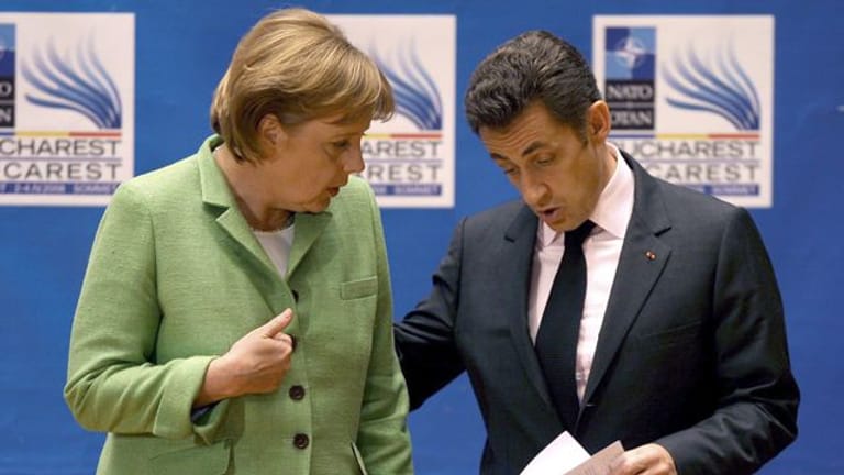 Die damalige Bundeskanzlerin Angela Merkel (l, CDU) spricht mit Nicolas Sarkozy, damals Präsident von Frankreich, am Ende der Eröffnungssitzung des NATO-Gipfels.
