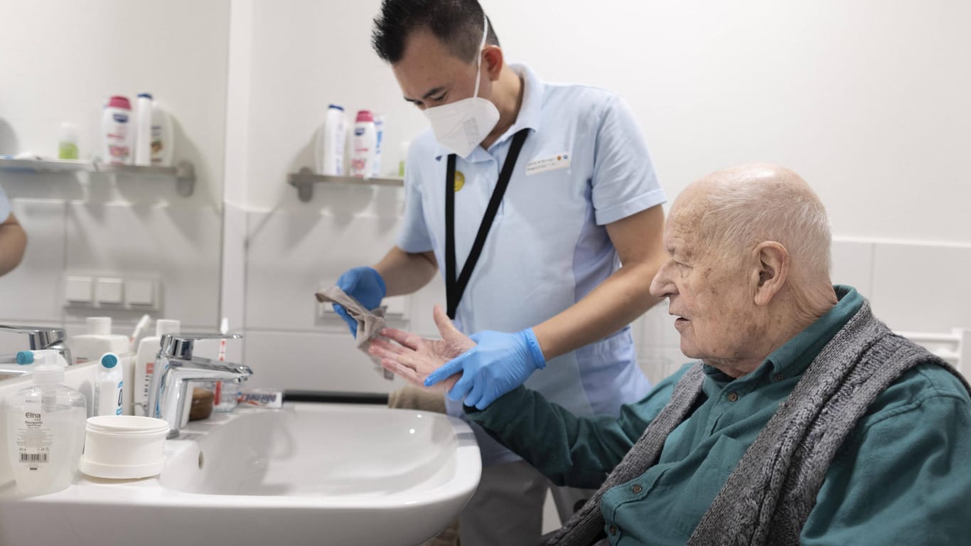 Ein Pfleger hilft einem Senioren beim Händewaschen (Symbolbild): Das Gehalt von Pflegekräften unterscheidet sich je nach Aufgaben und Kenntnissen – aber auch nach Bundesland.