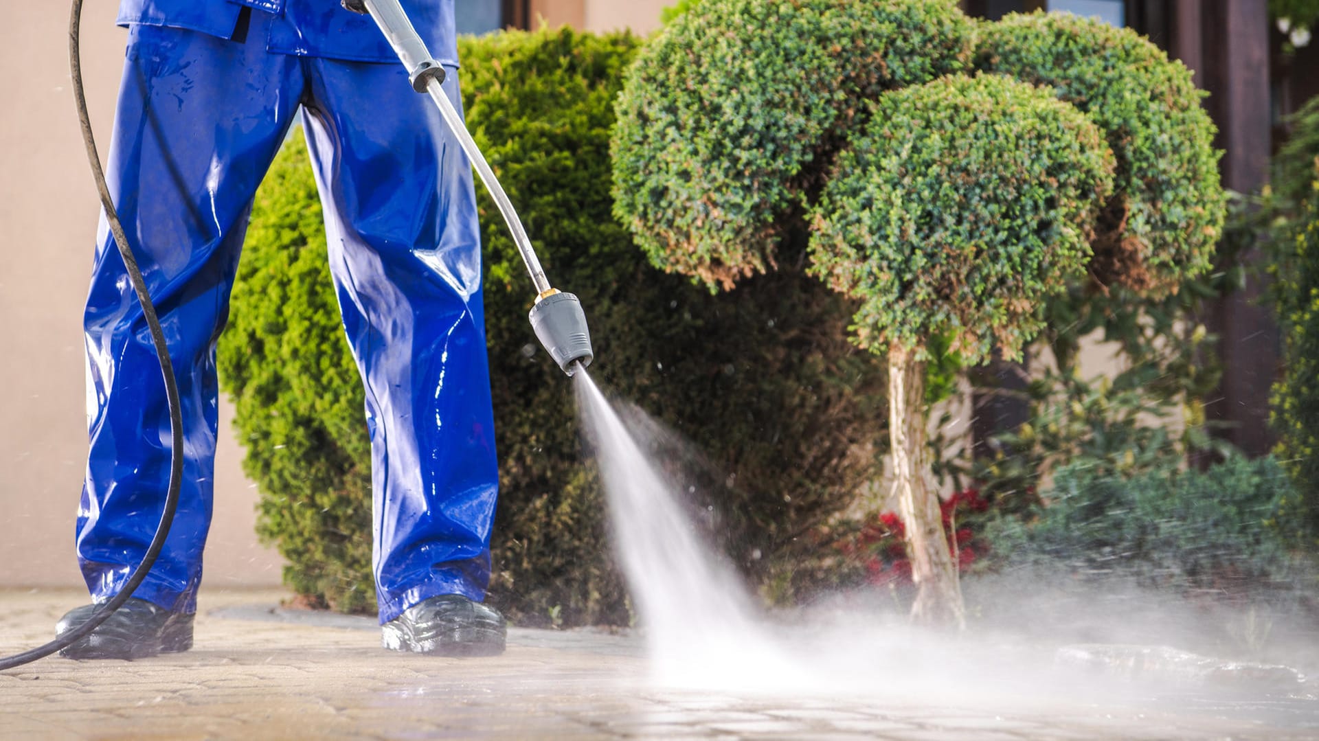 Reinigungsarbeiten: Eine wasserabweisende Hose schützt vor den Wasserspritzern des Hochdruckreinigers.