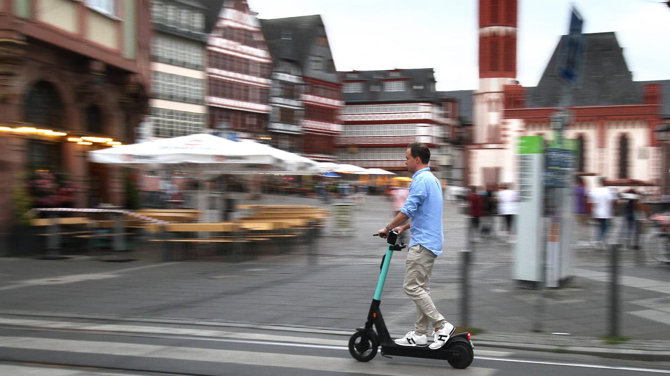 Ein E-Scooter-Fahrer am Römerberg (Symbolbild): Die Zahl der Roller in der City wird stark begrenzt.