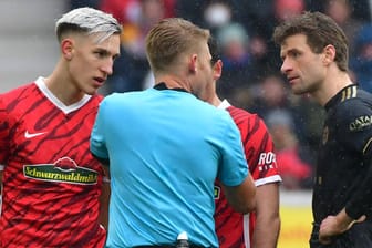 Wie geht's denn nun weiter? Nico Schlotterbeck, Schiedsrichter Christian Dingert und Thomas Müller (v. l.) diskutierten nach dem Wechselfehler der Bayern auf dem Spielfeld.
