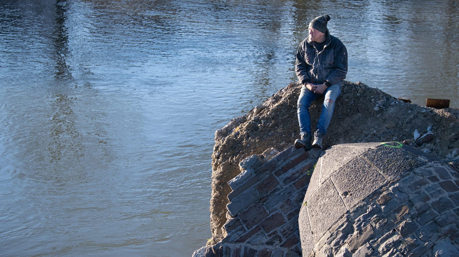 Ein Anwohner aus Insul im Ahrtal sitzt auf den Überresten der örtlichen Brücke: Der Starkregen, der im Sommer 2021 die katastrophale Flut in dieser Region auslöste, war eine Folge des Klimawandels. Je stärker die Atmosphäre sich erwärmt, desto häufiger und heftiger werden solche Wetterextreme.