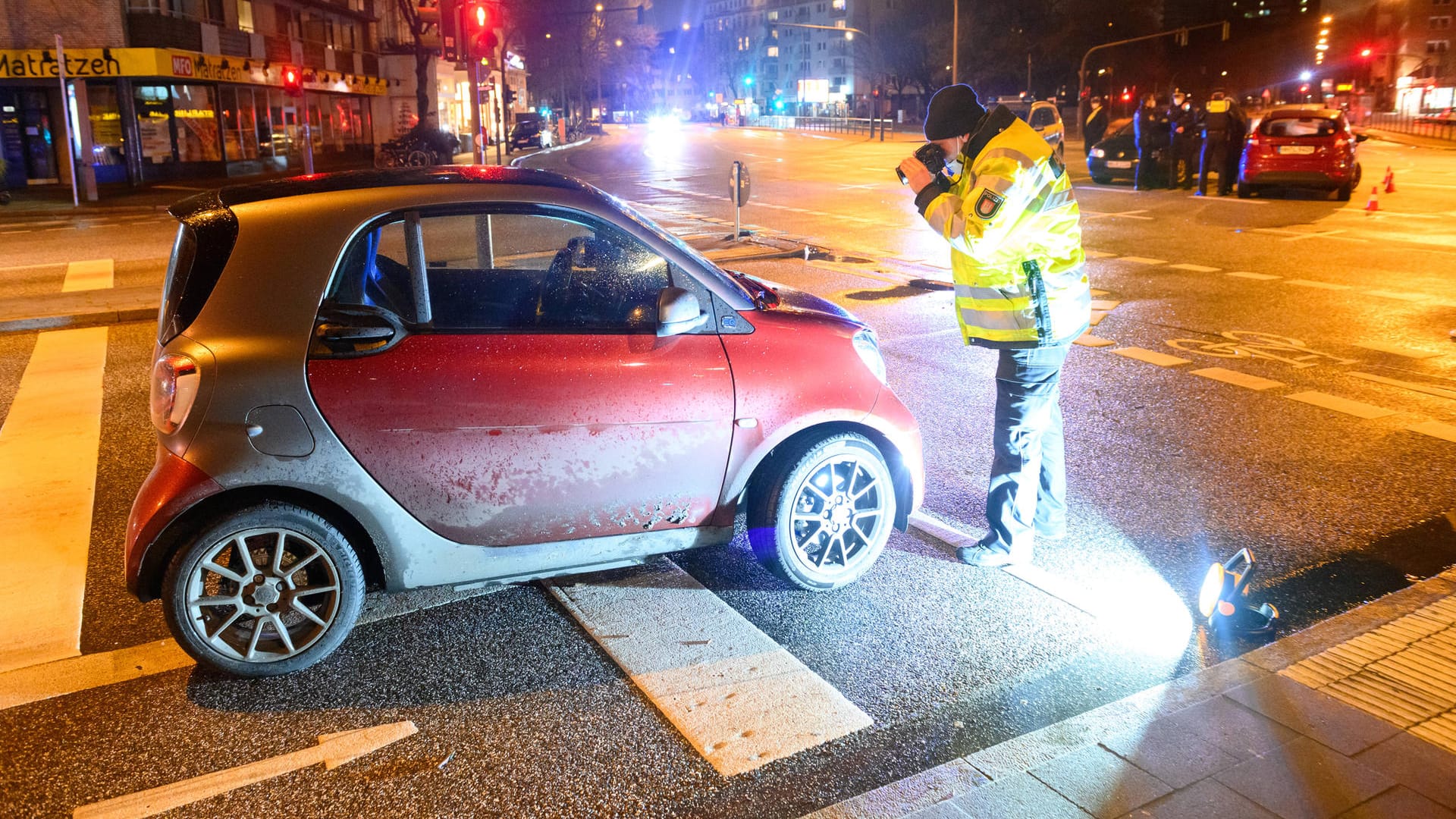 Ein Ermittler des Verkehrsunfalldienstes fotografiert das verunfallte Auto: Der angefahrene Polizist war gerade selbst mit der Aufnahme eines anderen Unfalls beschäftigt. Ein Ermittler des Verkehrsunfalldienstes fotografiert das verunfallte Auto: Der angefahrene Polizist war gerade selbst mit der Aufnahme eines anderen Unfalls beschäftigt.