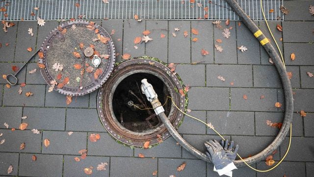 Ein Schlauch für die Heizöllieferung an einen Kunden in einem Mehrfamilienhaus ist am Füllstutzen eines Erdtanks befestigt.