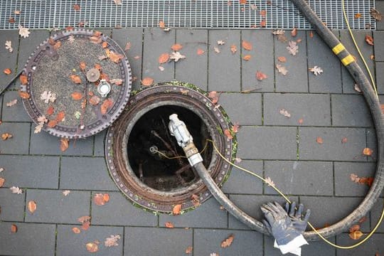 Ein Schlauch für die Heizöllieferung an einen Kunden in einem Mehrfamilienhaus ist am Füllstutzen eines Erdtanks befestigt.