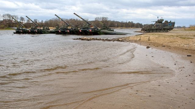 Ein Schützenpanzer vom Typ "Marder" fährt bei einer Bundeswehrübung am Elbestrand auf eine Schwimmschnellbrücke.