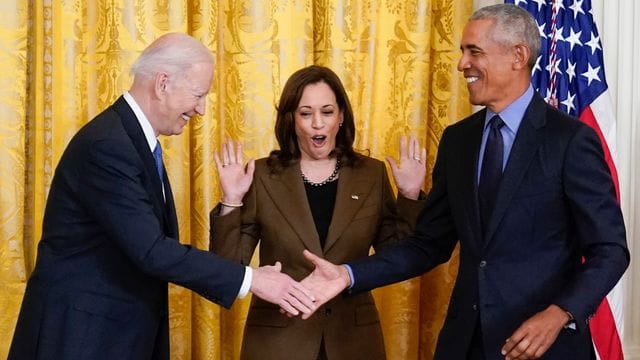 US-Vizepräsidentin Kamala Harris (M) reagiert auf den Handschlag von Präsident Joe Biden (l) und seinem Vorgänger Barack Obama.