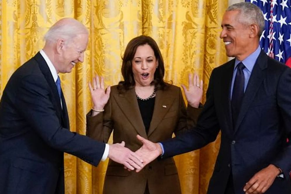 US-Vizepräsidentin Kamala Harris (M) reagiert auf den Handschlag von Präsident Joe Biden (l) und seinem Vorgänger Barack Obama.