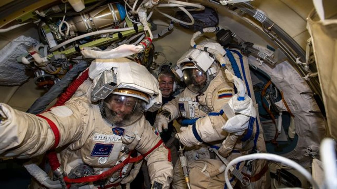 Die russischen Kosmonauten Anton Schkaplerow (l) und Pjotr Dubrow (r) bereiten sich mit Unterstützung von NASA-Astronaut Mark Vande Hei (hinten) auf einen Weltraumspaziergang vor.